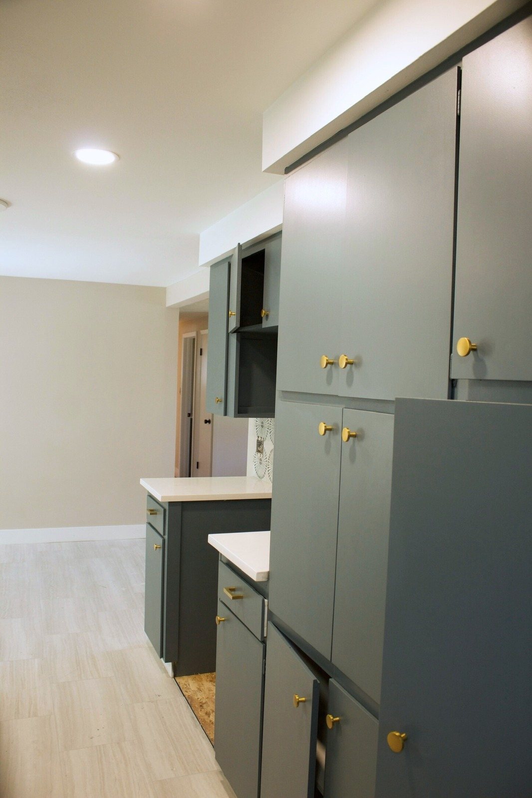 Smooth finished walls beside tall green painted cabinets